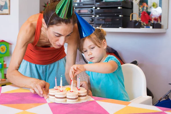 Criança e mãe colocando velas no bolo de festa — Fotografia de Stock