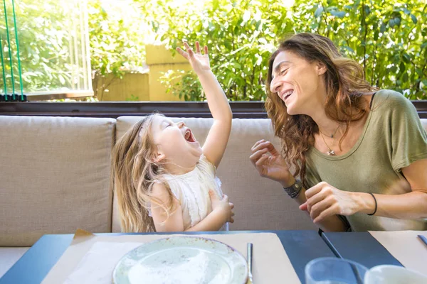 Frau und Mädchen lachen laut in Restaurant — Stockfoto