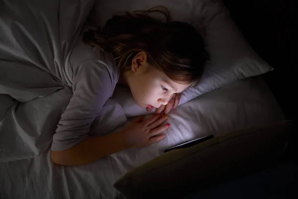 Niña Seis Años Acostada Cama Blanca Por Noche Viendo Teléfono Fotos De Stock