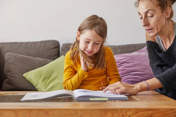 Mutter Hilft Ihrer Tochter Sechs Jahre Alt Hausaufgaben Machen Hause lizenzfreie Stockbilder