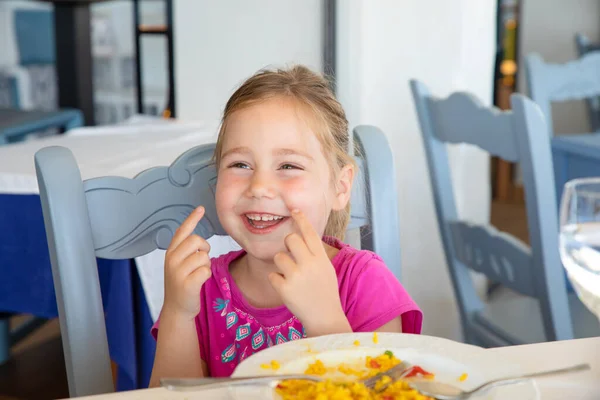 Menina rindo boca aberta no restaurante com prato de paella — Fotografia de Stock