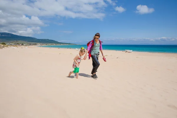 Žena a dívka kráčející po písku Bolonia Beach v Cádizu — Stock fotografie