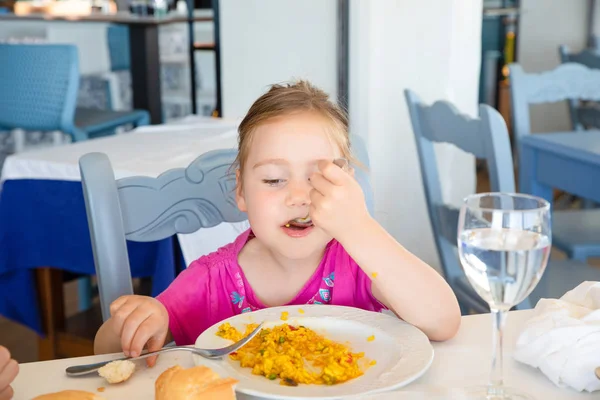 Porträt eines kleinen Mädchens beim Paella-Essen im Restaurant lizenzfreie Stockbilder