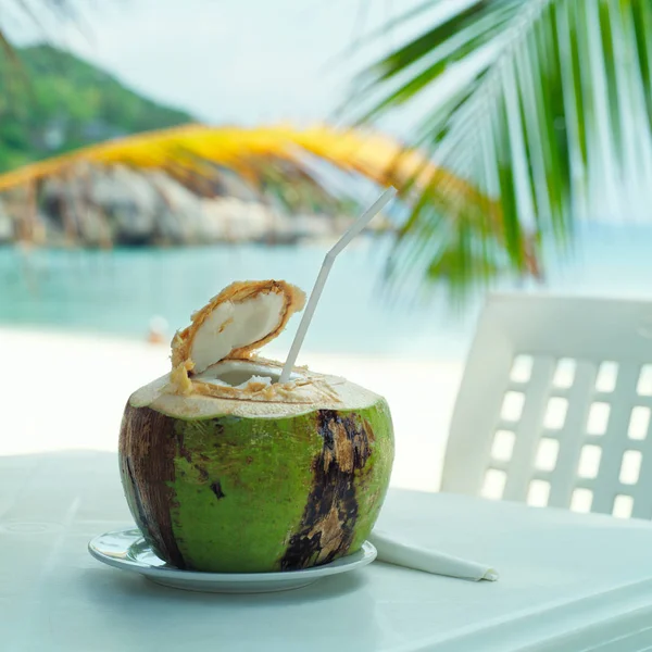 Coco, café de playa, en la mesa con fondo borroso de mar y —  Fotos de Stock