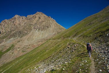 Bir grup insan üzerinde yeşil çimenli dağ Vadisi IC ile hiking