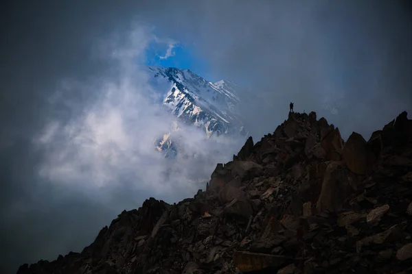 Joven excursionista permanecer en la cima de la montaña y mirando a val brumoso — Foto de Stock