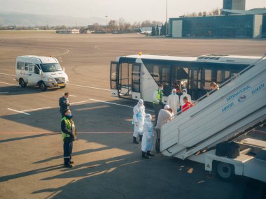 ALMATY, KAZAKHSTAN - 29 Mart 2020. Bir sağlık ve gümrük kontrol ekibi koronavirüs enfeksiyonlu ülkelerden gelen yolcularla karantinaya alınmak üzere ülkeye dönüş uçuşu yapıyor. Almaty Havaalanı.