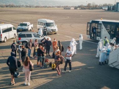 ALMATY, KAZAKHSTAN - 29 Mart 2020. Bir sağlık ve gümrük kontrol ekibi koronavirüs enfeksiyonlu ülkelerden gelen yolcularla karantinaya alınmak üzere ülkeye dönüş uçuşu yapıyor. Almaty Havaalanı.
