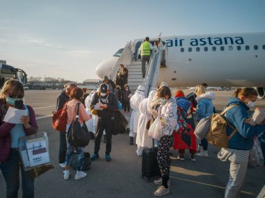 ALMATY, KAZAKHSTAN - 29 Mart 2020. Bir sağlık ve gümrük kontrol ekibi koronavirüs enfeksiyonlu ülkelerden gelen yolcularla karantinaya alınmak üzere ülkeye dönüş uçuşu yapıyor. Almaty Havaalanı.