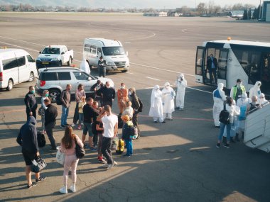 ALMATY, KAZAKHSTAN - 29 Mart 2020. Bir sağlık ve gümrük kontrol ekibi koronavirüs enfeksiyonlu ülkelerden gelen yolcularla karantinaya alınmak üzere ülkeye dönüş uçuşu yapıyor. Almaty Havaalanı.