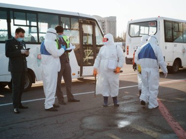 ALMATY, KAZAKHSTAN - 29 Mart 2020. Bir sağlık ve gümrük kontrol ekibi koronavirüs enfeksiyonlu ülkelerden gelen yolcularla karantinaya alınmak üzere ülkeye dönüş uçuşu yapıyor. Almaty Havaalanı.