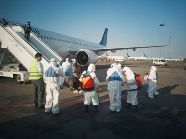 ALMATY, KAZAKHSTAN - 29 Mart 2020. Bir sağlık ve gümrük kontrol ekibi koronavirüs enfeksiyonlu ülkelerden gelen yolcularla karantinaya alınmak üzere ülkeye dönüş uçuşu yapıyor. Almaty Havaalanı.