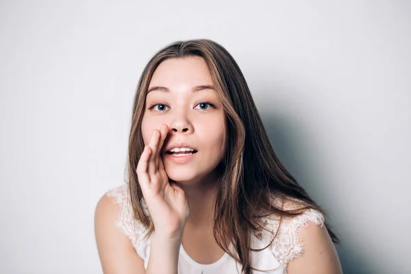 Hermosa chica que cuenta un secreto .Portrait joven feliz woman.Funny modelo chica susurrando sobre algo. Expresiones faciales —  Fotos de Stock