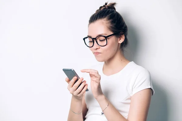 Neşeli genç Kızıl saçlı kız öğrencinin cep telefonu, haber yüklemesi onun sosyal ağ hesaplarını kontrol kullanarak sevimli gülümseme ile. Güzel kız cep telefonunuzda İnternet sörf