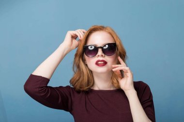 Moda trend Bahar, yaz. Mavi bir arka plan üzerinde siyah güneş gözlüğü güzel kadın.