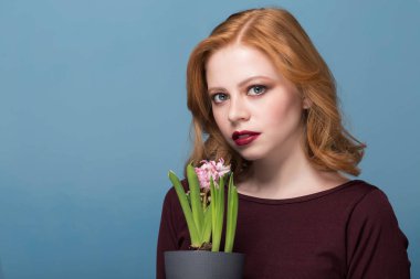 Taze sümbül çiçek tutan ve kamera için seyir çekici genç kadın portresi. Yakın çekim.