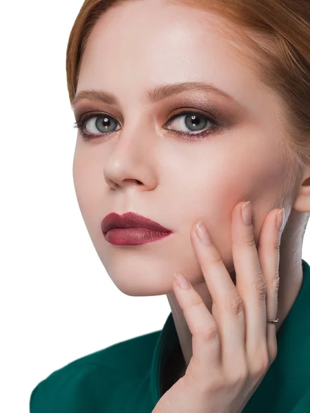 Redhead dziewczyna ręką piękny makijaż na twarzy wyglądający zbliżenie portret w zieloną kurtkę i zielone oczy — Zdjęcie stockowe