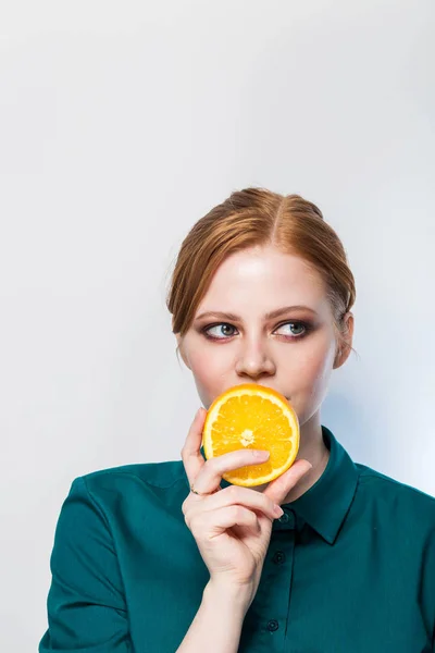 Potret wanita cantik dengan jeruk di tangannya, tampak dengan senyum ke samping. Salin ruang. Kesehatan, nutrisi, kecantikan, perawatan kulit . — Stok Foto