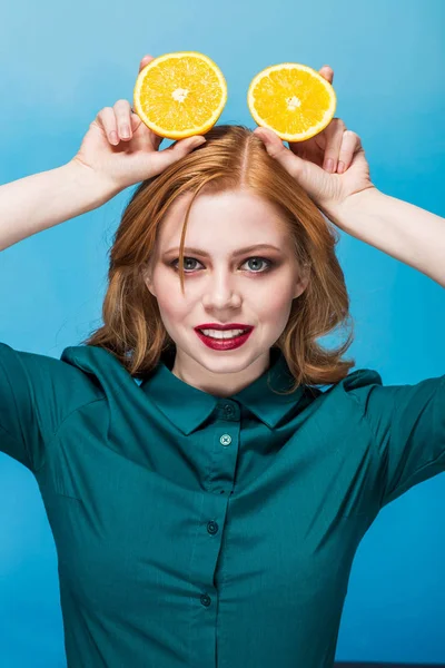Wanita cantik wajah dengan jeruk juicy di latar belakang biru — Stok Foto