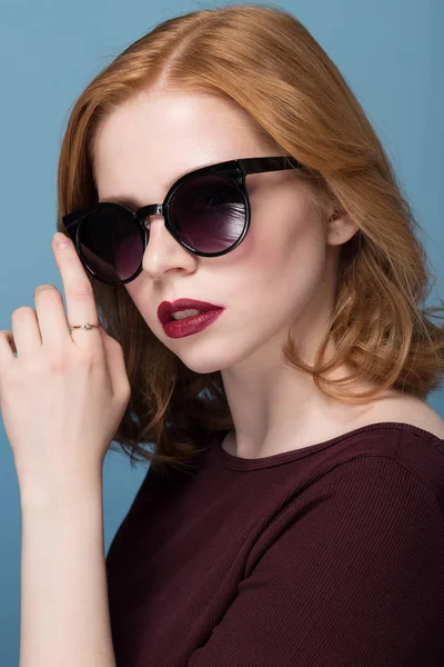 Mavi arka plan karşı güneş gözlüğü şık genç kadın portresi kapatın. Moda, glamour, moda, model — Stok fotoğraf