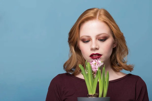 Close up retrato de uma jovem com flores jacinto em um fundo azul — Fotografia de Stock