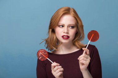 Mavi bir arka plan üzerinde iki şekerler genç bir kadın portresi. Seçim kavramı