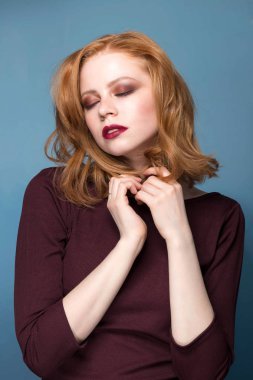 Şehvetli redhead kadın kapalı gözler mavi arka plan ile. Duygular, etkileyici yüz ifadeleri