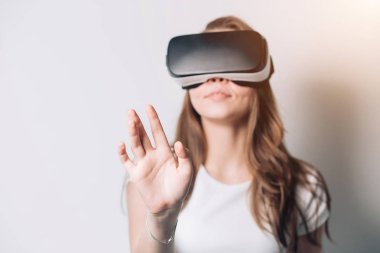 Sanal gerçeklik kulaklığı kullanan genç bir kadın.,