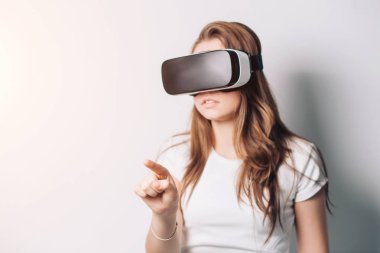 Genç kadın sanal gerçeklik bardaklarda Oyun oynama dijital tablet denetim sanal gerçeklik dokunmatik ekran kullanma.