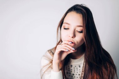 Beyaz arka plan üzerinde üzgün ve depresyonda bir kadının yakın çekim. Güzel kız duygu olmadan görünüyor.