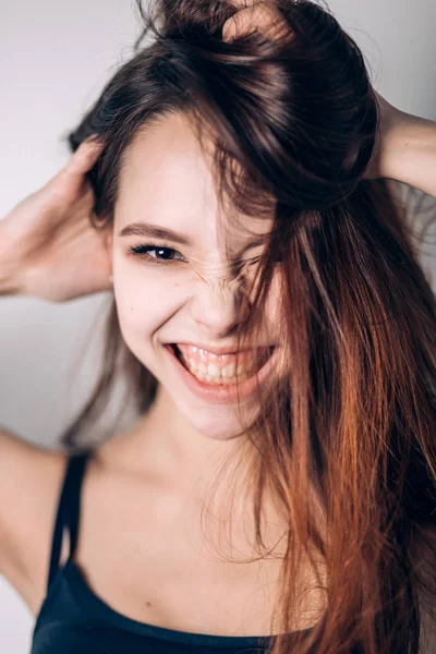 Loca chica emocional sobre fondo blanco. Retrato de una hermosa joven sonriente . —  Fotos de Stock