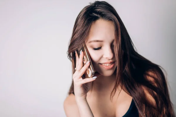 Una chica llamando por teléfono. Hermosa mujer utiliza un teléfono inteligente —  Fotos de Stock