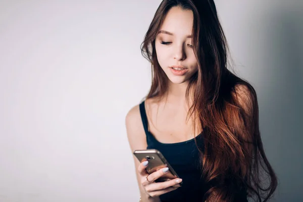 美しい若い女性がスマート フォンにメッセージを入力します。インターネット技術. — ストック写真