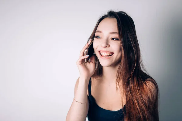 Una chica llamando por teléfono a casa. Mujer feliz utiliza un teléfono inteligente —  Fotos de Stock