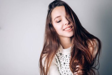 Çekici bir moda genç esmer kadın portresi. Kız bir şey hakkında düşünüyor, rüyalar, gülümsüyor.