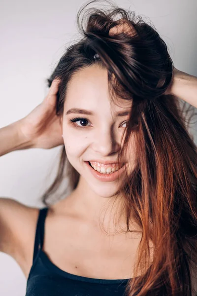 Loca chica emocional sobre fondo blanco. Retrato de una hermosa joven sonriente —  Fotos de Stock