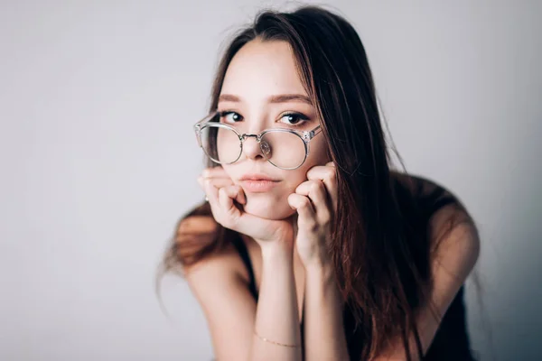 Ritratto di una bella donna seria con occhiali su sfondo bianco . — Foto Stock