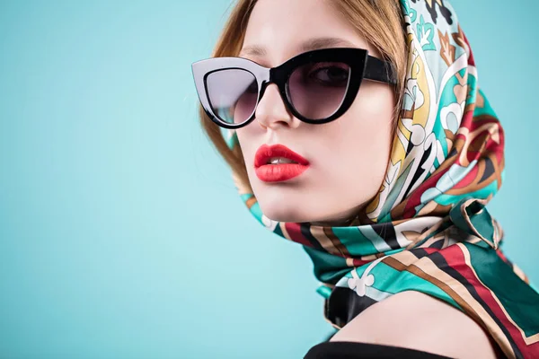 Модный портрет стильной молодой женщины в солнцезащитных очках, изолированный на синем фоне — стоковое фото