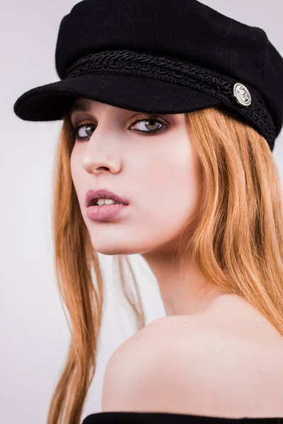 Retrato de joven modelo de chica con estilo en gorra negra, sombrero con maquillaje natural aislado sobre fondo blanco. Mirando la cámara — Foto de Stock