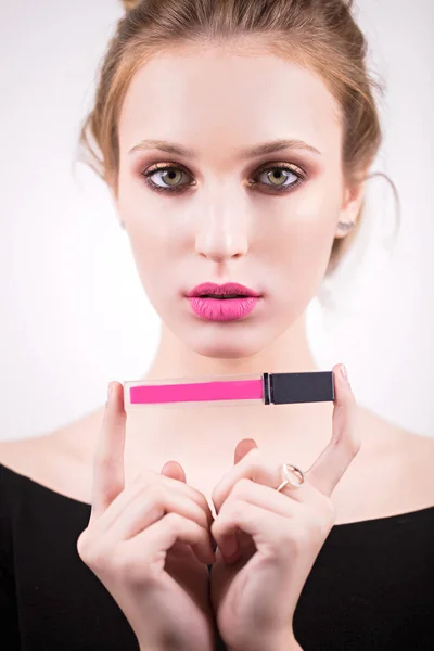 Mooie blonde in een Hollywood wijze, roze lippen, lippenstift, lipgloss in de hand. Het gezicht van de schoonheid. Het meisje met een zachte make-up — Stockfoto