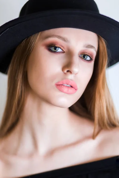 Retrato de mujer joven con estilo en sombrero con maquillaje natural sobre fondo blanco. Mirando la cámara —  Fotos de Stock