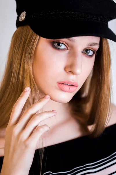 Primer plano retrato de mujer rubia sexy con maquillaje profesional, en una gorra. La chica mira a la cámara —  Fotos de Stock