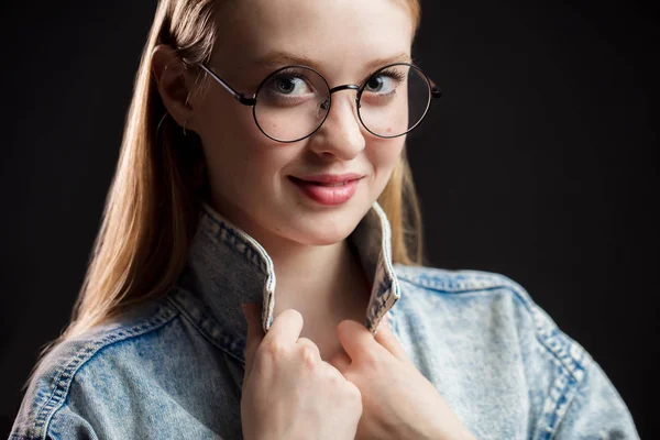 Close up retrato de bela jovem mulher usando óculos no fundo preto . — Fotografia de Stock