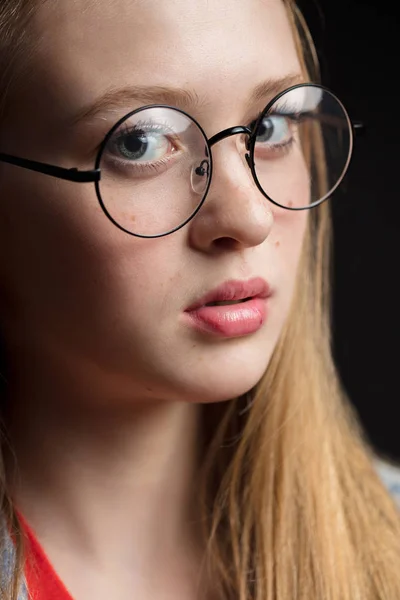 Close-up shot van de jonge vrouw in glazen op een zwarte achtergrond. — Stockfoto