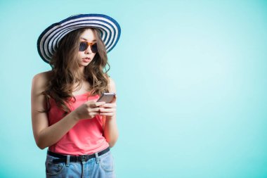 Seyir onun akıllı telefon şapkalı çekici genç kadın ve ciddi yüzü olan iletiyi okur