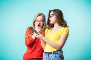 İki güzel kadın bir akıllı telefon kullanın. Kız uygulama, iletileri ekranda tarafından şaşırttı. Teknolojileri.