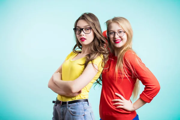 Studio portret van vriendinnen in lichte kleding en de bril op een blauwe achtergrond — Stockfoto