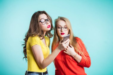 Cidden bakarak bir smartphone tutan iki güzel kadın