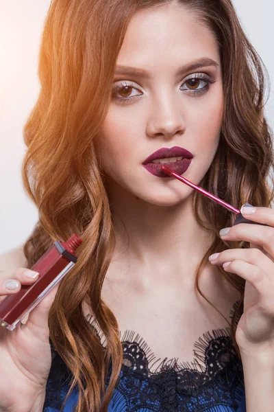 Mooi meisje legt op de lippen lippenstift, lipgloss, close-up — Stockfoto