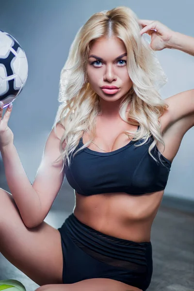 Portrait of a girl, sexy beautiful blonde woman in black sports underwear, bra, breast, ball, with blue eyes, makeup, curls, white background, sports, crossfit, fitness, close-up — Stock Photo, Image